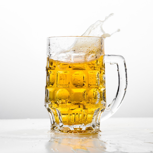 Beer splashing in glasses on white - Foto, afbeelding