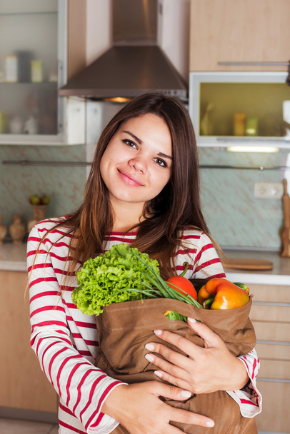 jeune souriant caucasien ménagère avec sac plein de légumes
 - Photo, image