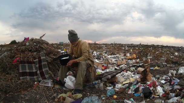 uomo disoccupato discarica senzatetto sporco cercando rifiuti alimentari in discarica video sociale
 - Filmati, video