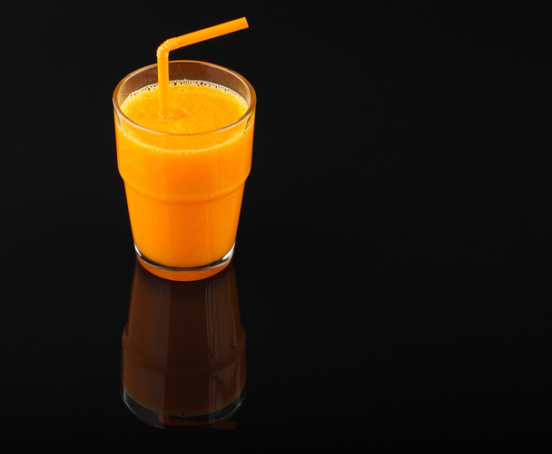 pumpkin smoothie in glass and pieces of pumpkin  on black - 写真・画像