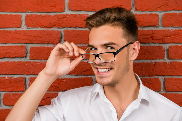 subtle handsome man holding his glasses - Foto, afbeelding