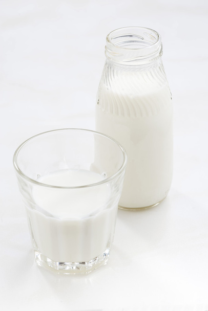 bottle and glass of milk on a white background, vertical - Фото, зображення