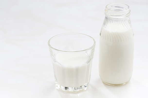 bottle and glass of milk on a white background - Фото, изображение