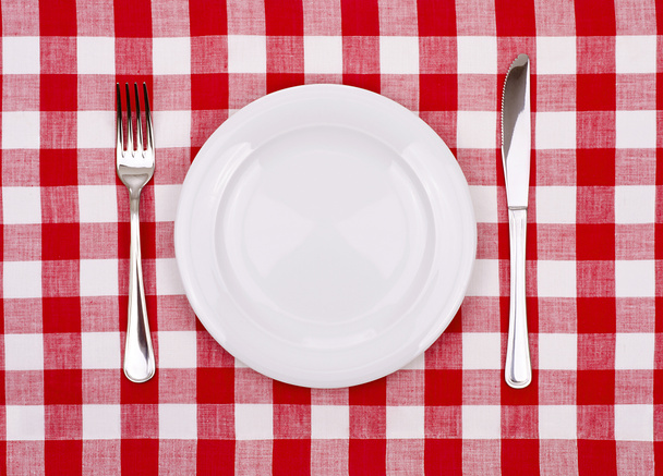 Plate knife and fork on a checkered tablecloth. - Photo, Image