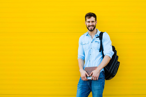 handsome man with backpack on yellow - Fotografie, Obrázek