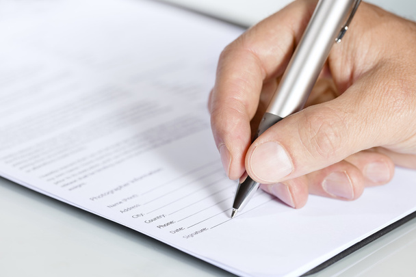 Close-up shot of hand signing a document - Photo, Image