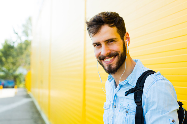 handsome man with backpack on yellow - Foto, Imagen