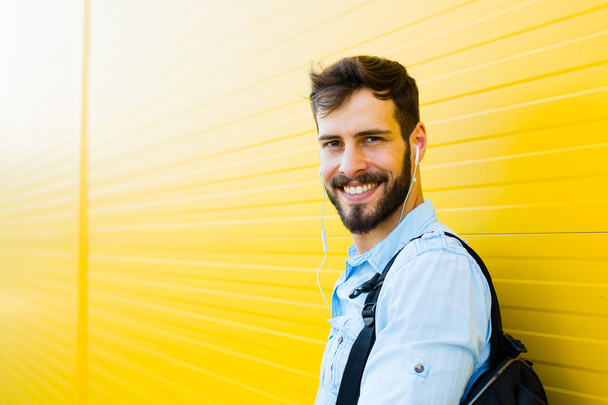 handsome man with backpack on yellow - Photo, Image