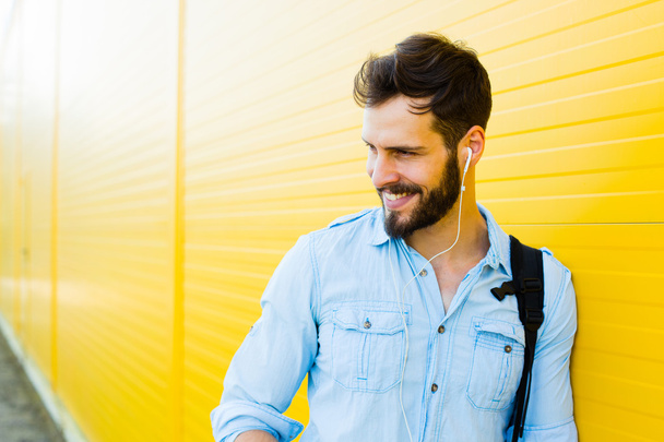 handsome man with backpack on yellow - Photo, image