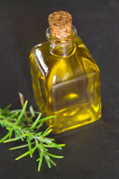 yellow oil bottle with rosemary - Fotó, kép