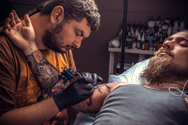 Maître faire un tatouage en studio de tatouage
 - Photo, image