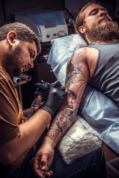Καλλιτέχνης τατουάζ κάνει τατουάζ εικόνες στο στούντιο τατουάζ - Φωτογραφία, εικόνα