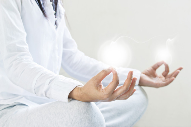 vrouw mediteren van zuiverheid energie inzicht op grijze achtergrond - Foto, afbeelding