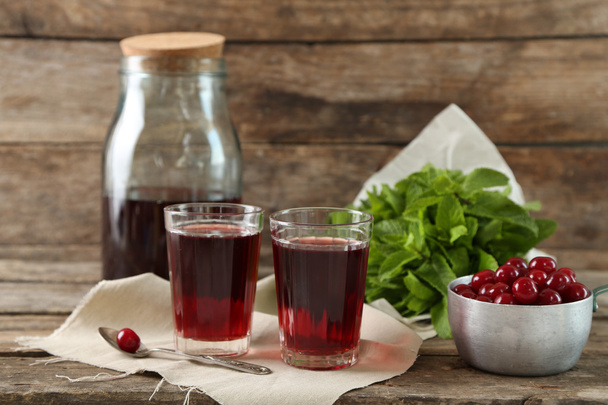 Sweet homemade cherry juice on table, on wooden background - Фото, изображение