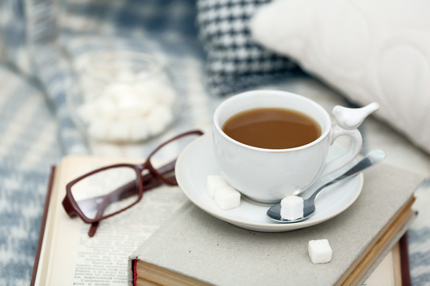 Cup of coffee with books on sofa in living room - Foto, Imagen