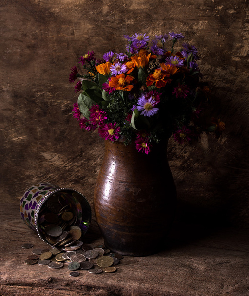 Bloemen in vaas en stapel van oude munten - Foto, afbeelding