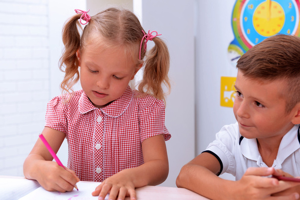 Little girl drawing at the desk in classroom - Fotoğraf, Görsel