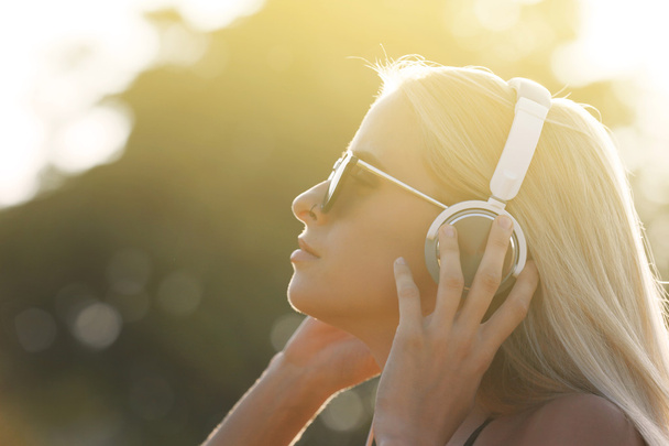 Young woman listening to music in the park - Foto, imagen