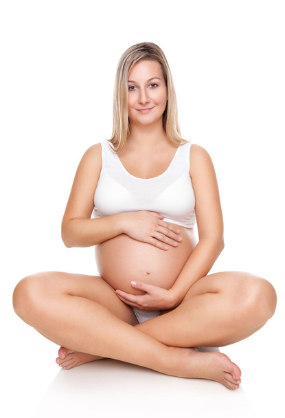 Portrait of a pregnant woman sitting on floor and holding belly - Foto, Imagem