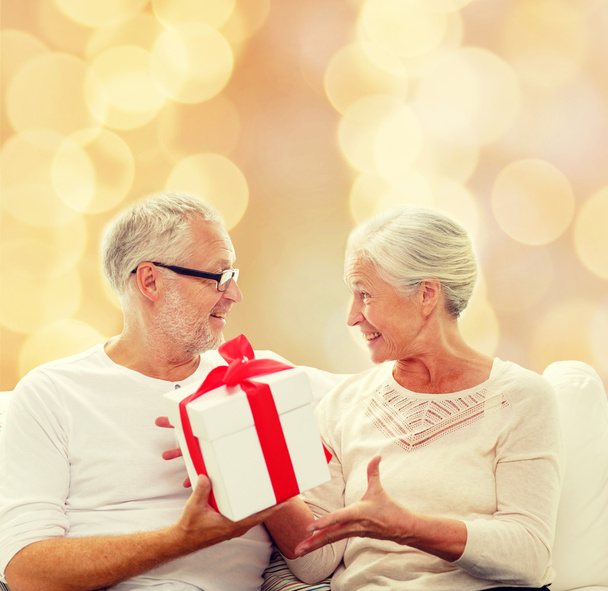 happy senior couple with gift box at home - Foto, Imagem