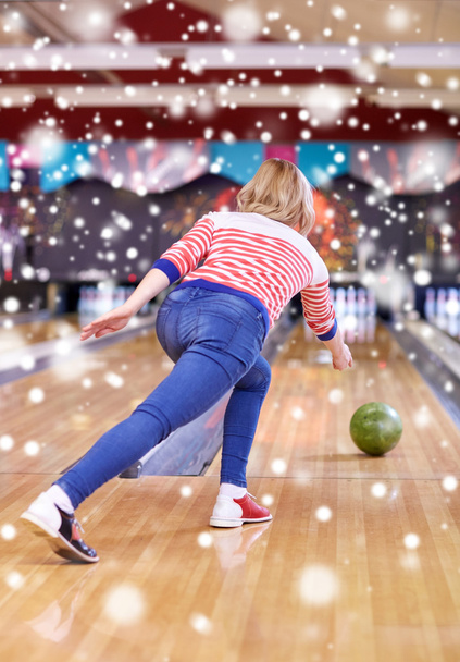happy young woman throwing ball in bowling club - Foto, Imagem