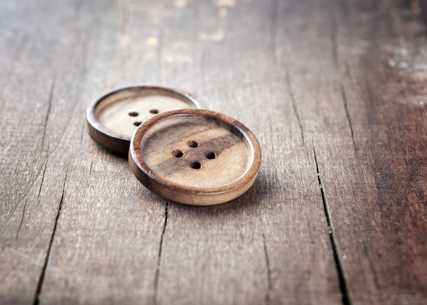 Button on a wooden table - Фото, зображення