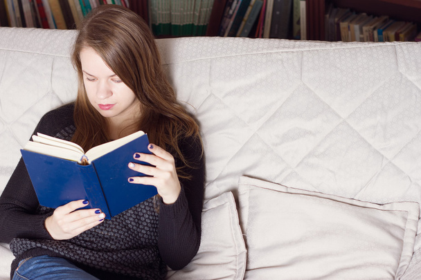 jeune femme lisant un livre sur canapé
 - Photo, image