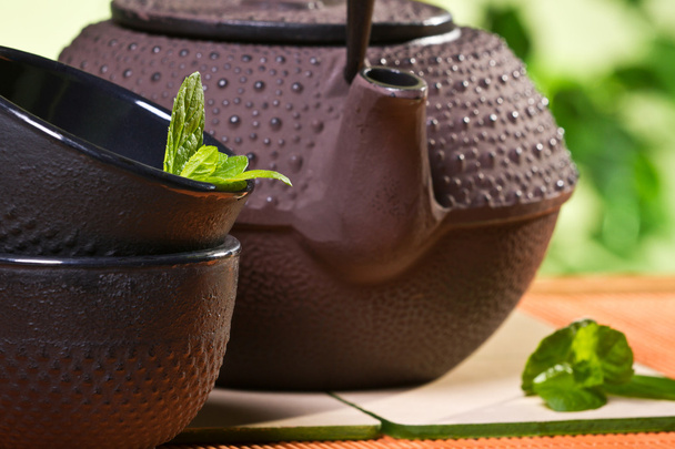 frische Teeblätter und Wasserkocher im Garten - Foto, Bild