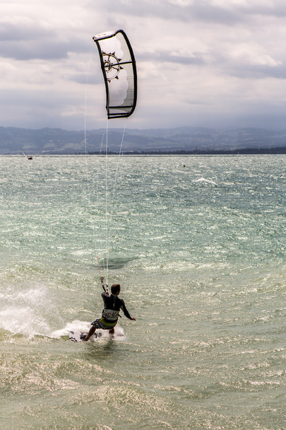 Kiteboarder surfen golven met kiteboard - Foto, afbeelding