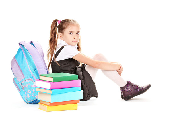 Beautiful little girl, books and a backpack isolated on white - Foto, immagini