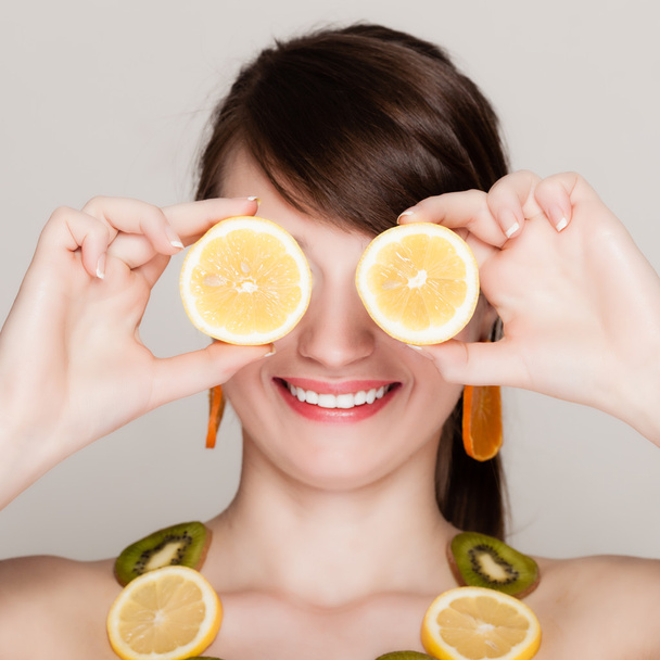 Diet. Girl with necklace of fresh citrus fruits - Foto, imagen