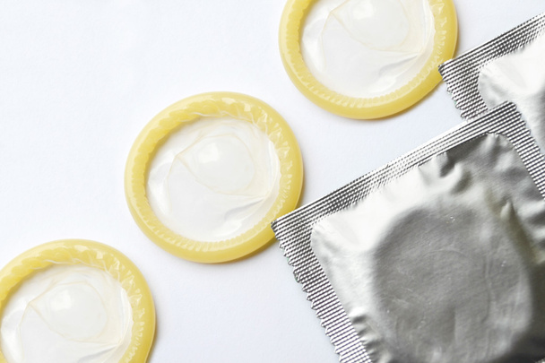 Pari valkoisella eristettyä kondomia
 - Valokuva, kuva