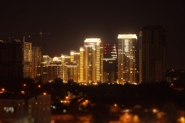 Освещение ночного строительства высотного здания на городской улице
 - Фото, изображение