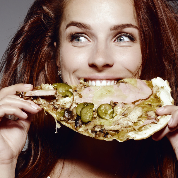 ピザを食べる若い女性の美しいクローズ アップ肖像画。健康的です - 写真・画像
