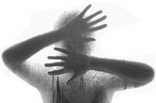Mulher de terror por trás do vidro fosco, estilo preto e branco, mão e corpo embaçados, foco suave
 - Foto, Imagem