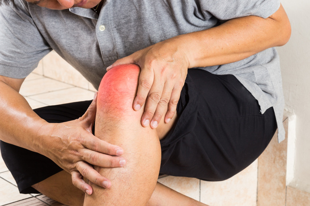 Homme mûr souffrant d'articulation douloureuse du genou assis sur des marches
 - Photo, image