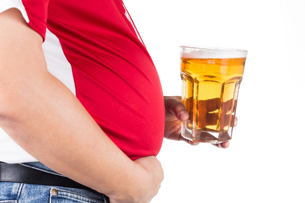 Толстяк с большим животом держит стакан освежающего холодного пива
 - Фото, изображение
