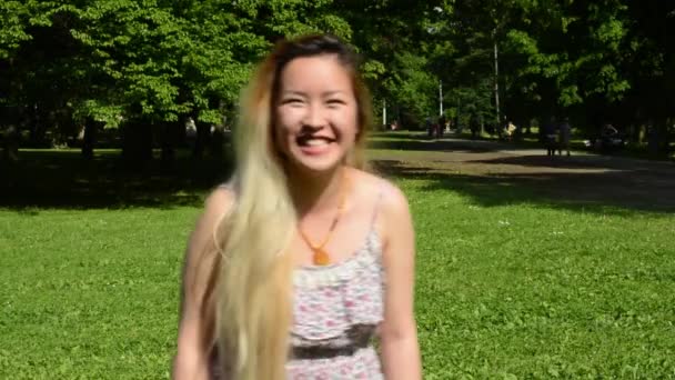 jong aantrekkelijk gelukkig aziatische vrouw loopt en lacht in het park - Video