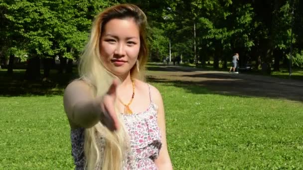 młoda atrakcyjna azjatycka kobieta naciśnij ciało w parku - zbliżenie - Materiał filmowy, wideo