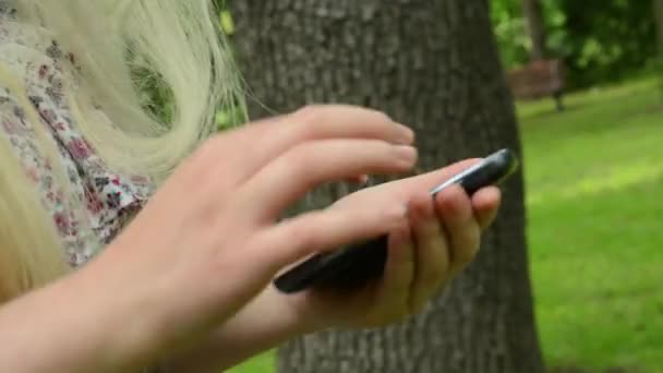 mujer camina y trabaja con smartphone en el parque - detalle - steadicam
 - Metraje, vídeo
