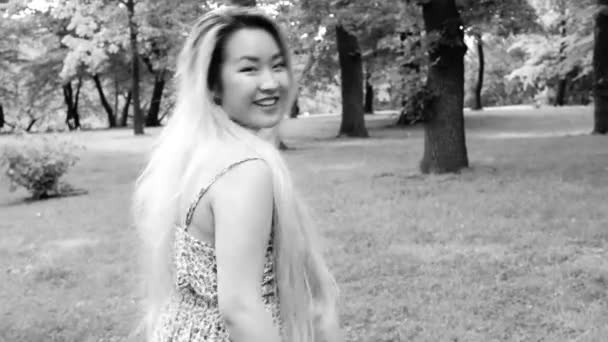 young asian attractive woman walks and shows: come here - steadicam - black and white - Footage, Video