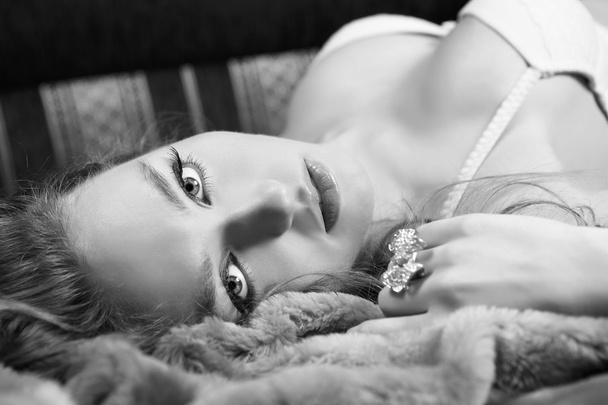 The young woman lays on fur. - Fotó, kép