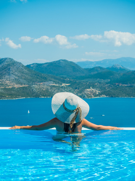 Picture of a woman in swimming-pool watching the sea - Photo, Image