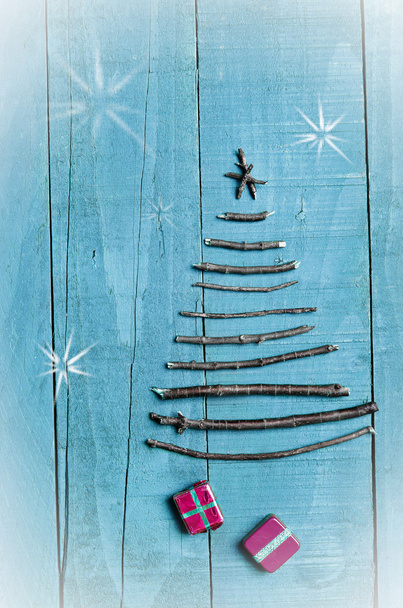 Christmas tree made from dry sticks on wooden, blue background. Snow flaks image. Christmas tree ornament, craft, gifts. - Photo, Image