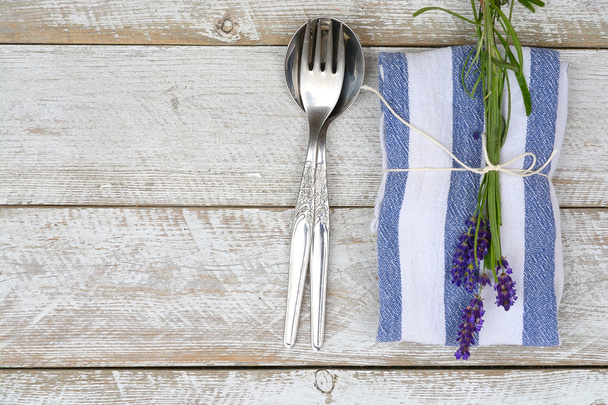srebrne sztućce i niebieski serwetka ręcznik kuchenny z lawendy ozdoba i puste miejsce w stylu rustykalnym vintage - Zdjęcie, obraz