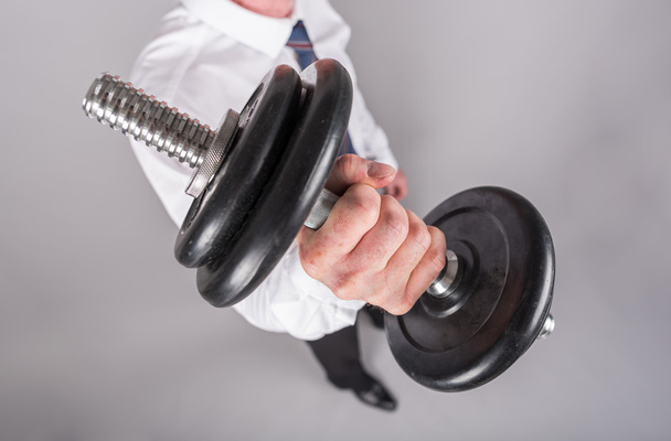 Businessman lifting a dumbbell - Photo, Image