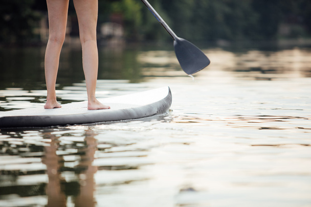 clouse-up of a woman legs on paddleboard - Фото, зображення