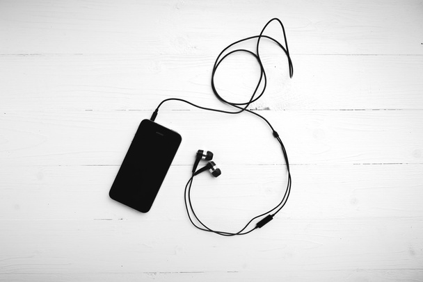teléfono celular con auriculares estilo de tono de color blanco y negro
 - Foto, Imagen