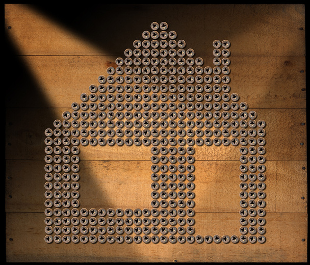 Símbolo de la casa - Tornillos sobre fondo de madera
 - Foto, imagen