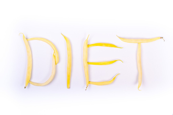 Keltaisia papuja valkoisella pohjalla. ruokavalion käsite
 - Valokuva, kuva